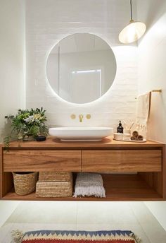 a bathroom with a round mirror above the sink