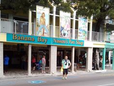 a man is walking down the street in front of a banana bay museum and shop