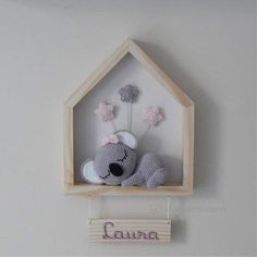 a stuffed animal in a wooden frame hanging on the wall