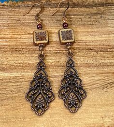 Long antique copper filigree earrings with Czech crystal and garnet gemstones. These long filigree earrings are very lovely, not too heavy! They are 3 inches long and 3/4 of an inch wide. The square table Kurt Czechoslovakian crystals really make the design pop. Garnet is the birthstone for January. All my jewelry comes gift boxed with a custom Shelly Mariposa Design butterfly card ready for gift giving, whether it is a gift for you or someone special. Your satisfaction is very important to me. Antique Copper Earrings In Antique Gold, Elegant Bronze Copper Earrings, Antique Finish Copper Earrings As Gift, Elegant Handmade Copper Chandelier Earrings, Antique Copper Earrings For Gift, Elegant Copper Chandelier Earrings, Vintage Copper Dangle Jewelry, Handmade Antique Copper Earrings, Vintage Copper Jewelry With Intricate Design