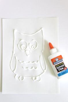 an image of a white owl with orange paint on it's face next to a bottle of glue