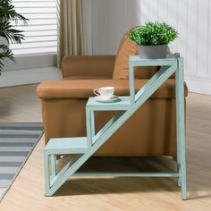 a coffee table with a potted plant sitting on top of it next to a couch