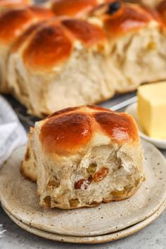 a piece of bread that has been baked on a plate with butter and cheese in the background