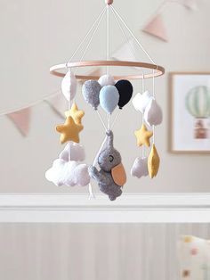 a baby crib mobile with stuffed animals hanging from it's sides and stars