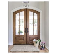 a pair of boots sitting on top of a rug in front of a wooden door