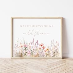 a wooden frame with flowers and the words in a field of roses she is a wildflower