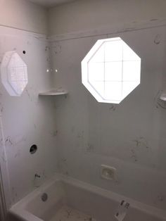 an empty bathroom with white walls and no shower curtain