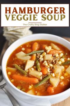 a bowl of hamburger veggie soup on top of a wooden table