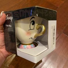 someone is holding up a beauty and the beast coffee cup in a box with its lid open