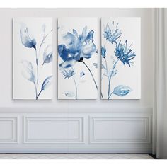 three blue flowers are hanging on the wall in this room with white walls and flooring