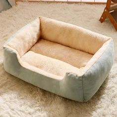 a dog bed is on the floor in front of a chair and rug with white fur