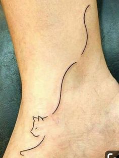 a woman's foot with a cat tattoo on it