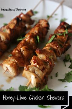 honey - lime chicken skewers on a plate with parsley sprigs