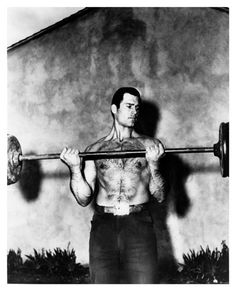 a man holding a barbell in front of his chest