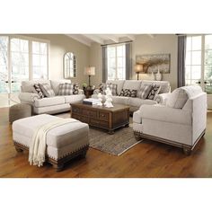 a living room filled with furniture on top of a hard wood floor covered in lots of windows