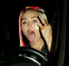 a woman sticking her tongue out while driving