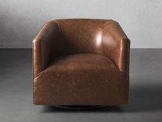 a brown leather chair sitting on top of a gray floor