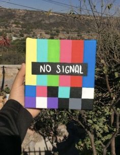 a hand holding up a colorful piece of paper with the words no signal on it