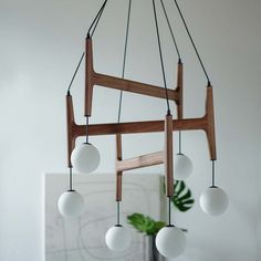 an image of a wooden chandelier with white balls hanging from it's sides