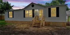 a mobile home with stairs leading up to the front door and steps down to the second floor