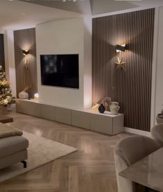 a living room filled with furniture and a christmas tree in front of a flat screen tv