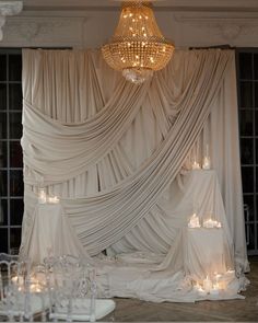 an elegant wedding setup with candles and drapes