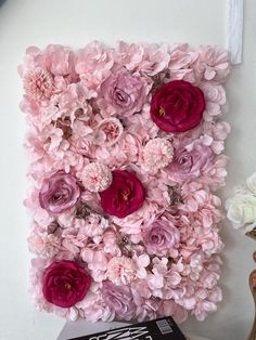 pink and red flowers are arranged on the wall