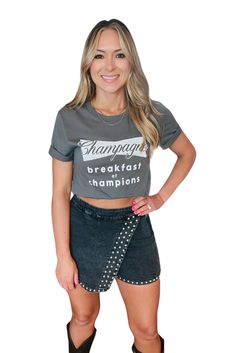 woman wearing a graphic tee that reads: champagne breakfast of champions with a black denim acid washed skort with stud detailing Denim Skort, Studded Denim, Concert Looks, Acid Wash Denim, Cozy Sweater, Hats For Sale, Dress Romper, Acid Wash, Cozy Sweaters