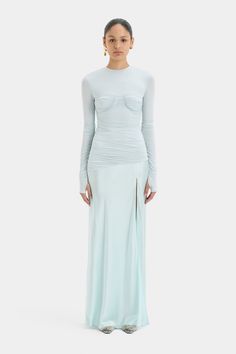 The Alessia Draped Gown is a long sleeved, full length dress crafted from fluid viscose jersey layered with a lustrous satin sheen in a soft ice blue colourway. Offering a fitted upperhalf with an exposed bra detail and gathering before draping into a relaxed narrow skirt with a split detail. Long Sleeve Maxi Dress With Ruched Bodice, Gala Long Sleeve Maxi Dress With Ruched Bodice, Fitted Long Sleeve Pre-draped Maxi Dress, Draped Gown, Drape Gowns, Drape Panel, Full Length Dress, Dress Crafts, Underwire Bra