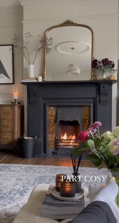 a living room with a fire place and flowers on the coffee table in front of it