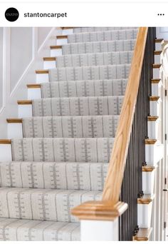 a staircase with white carpet and wooden handrails