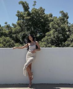 a woman leaning against a wall with her hand on the side