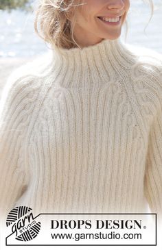 a woman wearing a white turtle neck sweater with braids on her head and smiling at the camera