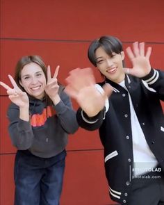 two young people posing for a photo with their hands in the air