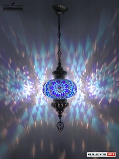 a blue chandelier hanging from a ceiling in front of a dark background with lights