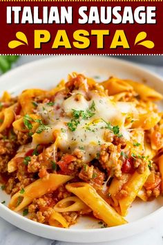 a white plate topped with pasta covered in sauce and cheese, on top of a marble table