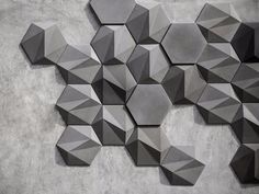 an abstract wall sculpture made out of hexagonal shapes on concrete background with cement flooring