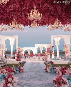 an outdoor wedding setup with flowers and chandeliers