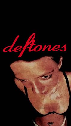 a man wearing a black bra with the words deftones on it