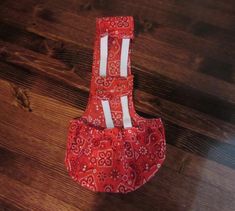 a red and white patterned bag sitting on top of a wooden floor