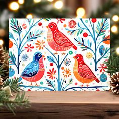 a christmas card with two birds on it and pine cones in front of the cards