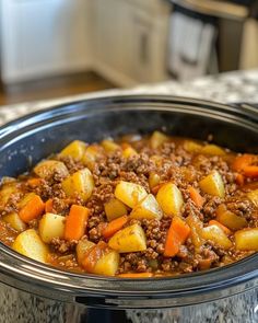 a crock pot filled with ground beef and carrots