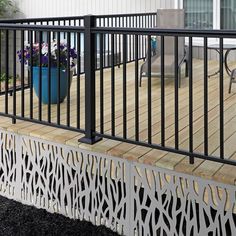 a deck with black iron railing and flower pot