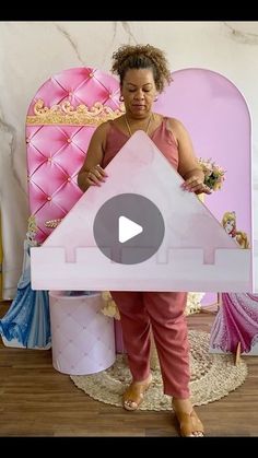 a woman standing in front of a pink bed