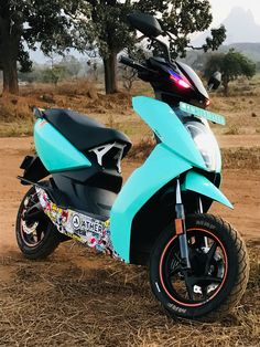 a blue motorcycle parked on top of a dry grass field