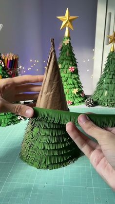 someone is making a christmas tree out of paper