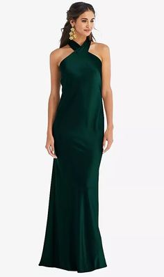 a woman in a long green dress with one shoulder and an open back, posing for the