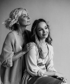 two women sitting next to each other posing for a black and white photo with their arms around one another