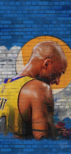 a painting of a basketball player with his head in his hands, on the side of a brick wall