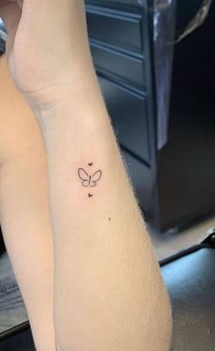 a woman's arm with a small butterfly tattoo on the left side of her wrist